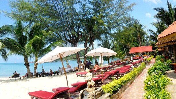 A beachside resort with sun loungers, umbrellas, and palm trees. - Koh Chang Resort Spa (Ko Chang)