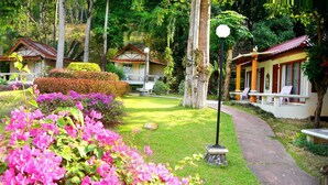 A garden with a pathway, benches, and traditional-style buildings. - Koh Chang Resort Spa (Ko Chang)