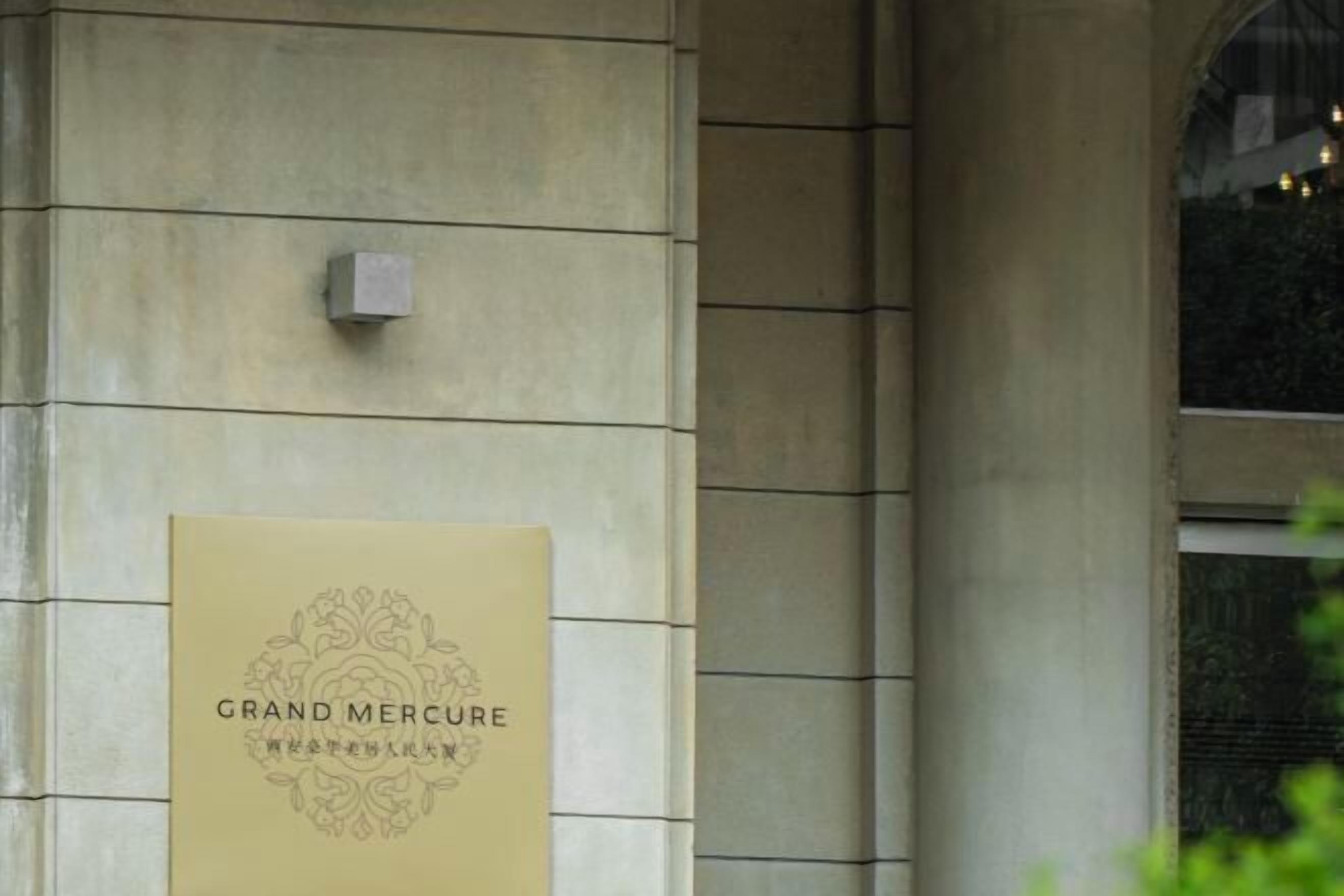 Eine Gebäudefassade mit einem Schild, auf dem 'GRAND MERCURE WESTFRI' steht.