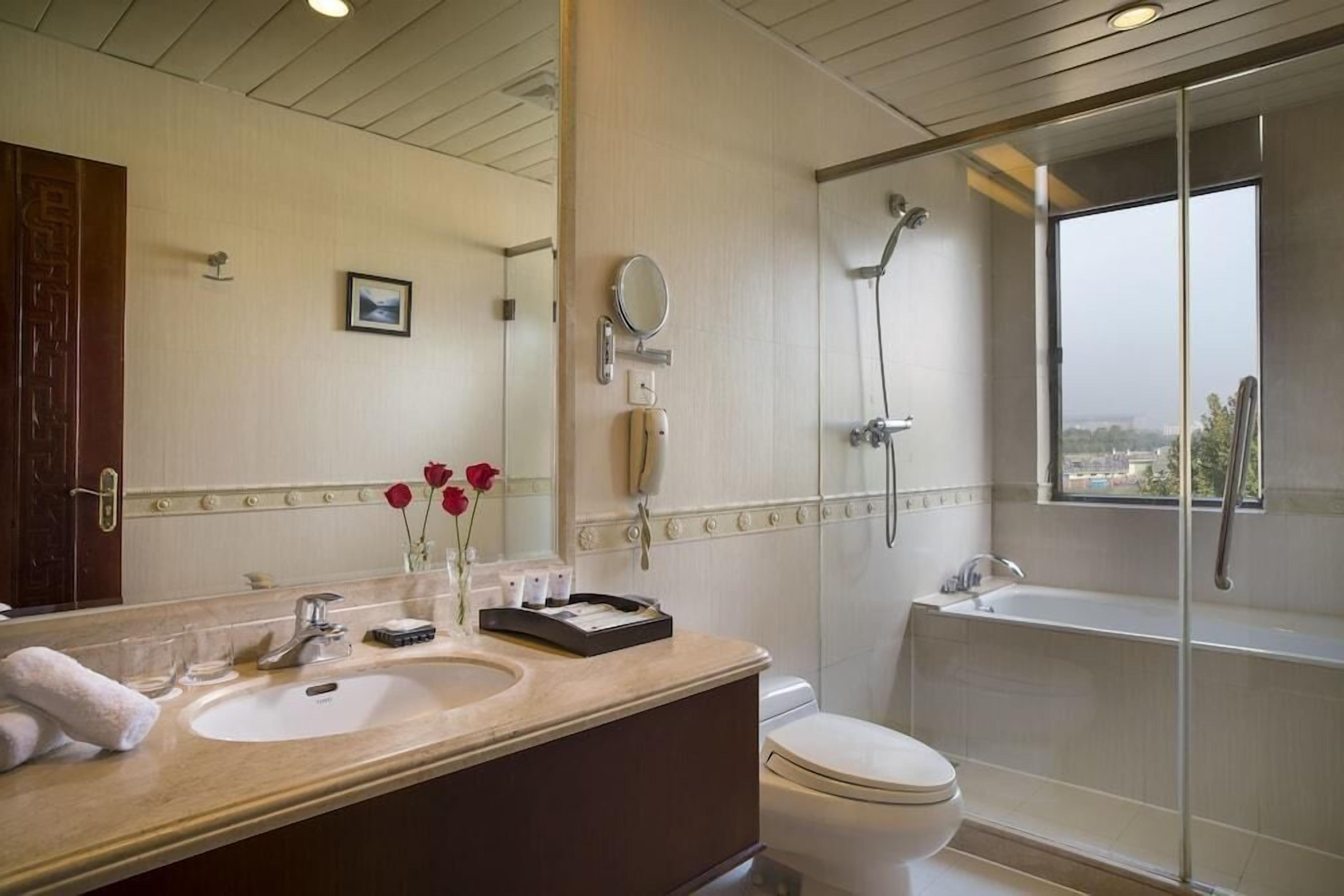 Ein Badezimmer mit Waschtisch, Spüle, Spiegel und Badewanne.