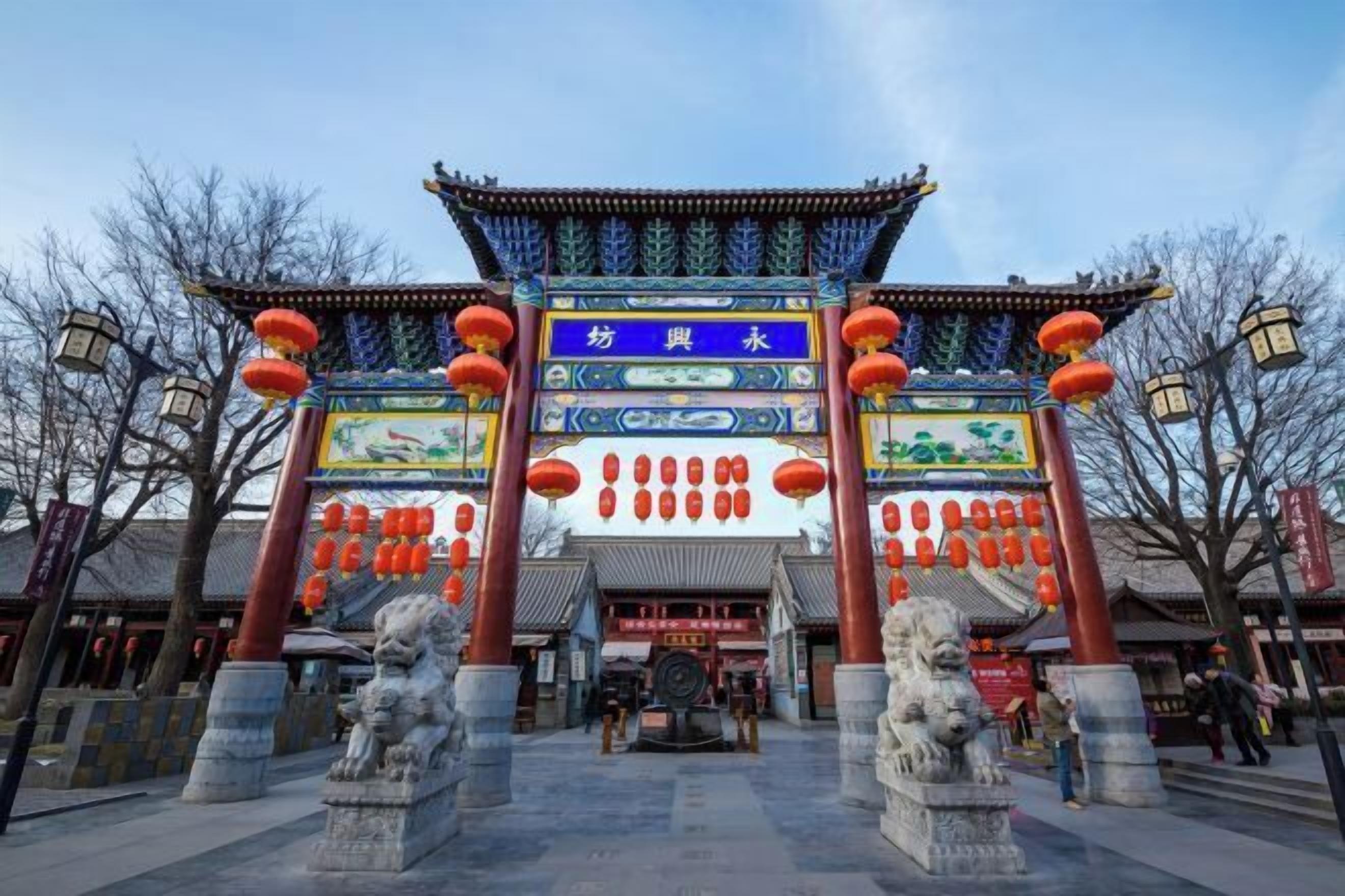 A traditional Chinese gate with intricate designs and red lanterns.