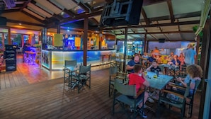 Un restaurant situé à l’intérieur, doté d’un plancher, de tables et de chaises en bois.