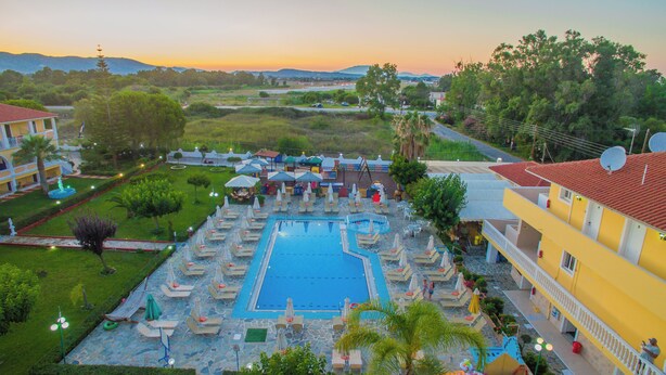 Un complexe hôtelier doté d’une piscine, de chaises longues et offrant une vue sur le paysage environnant.