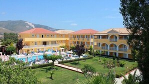 Un hôtel doté d’une piscine, de plusieurs balcons et d’un jardin bien entretenu.
