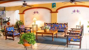 A room with a sofa set, chairs, a coffee table, and a potted plant. - Vallarta Sol (Puerto Vallarta)