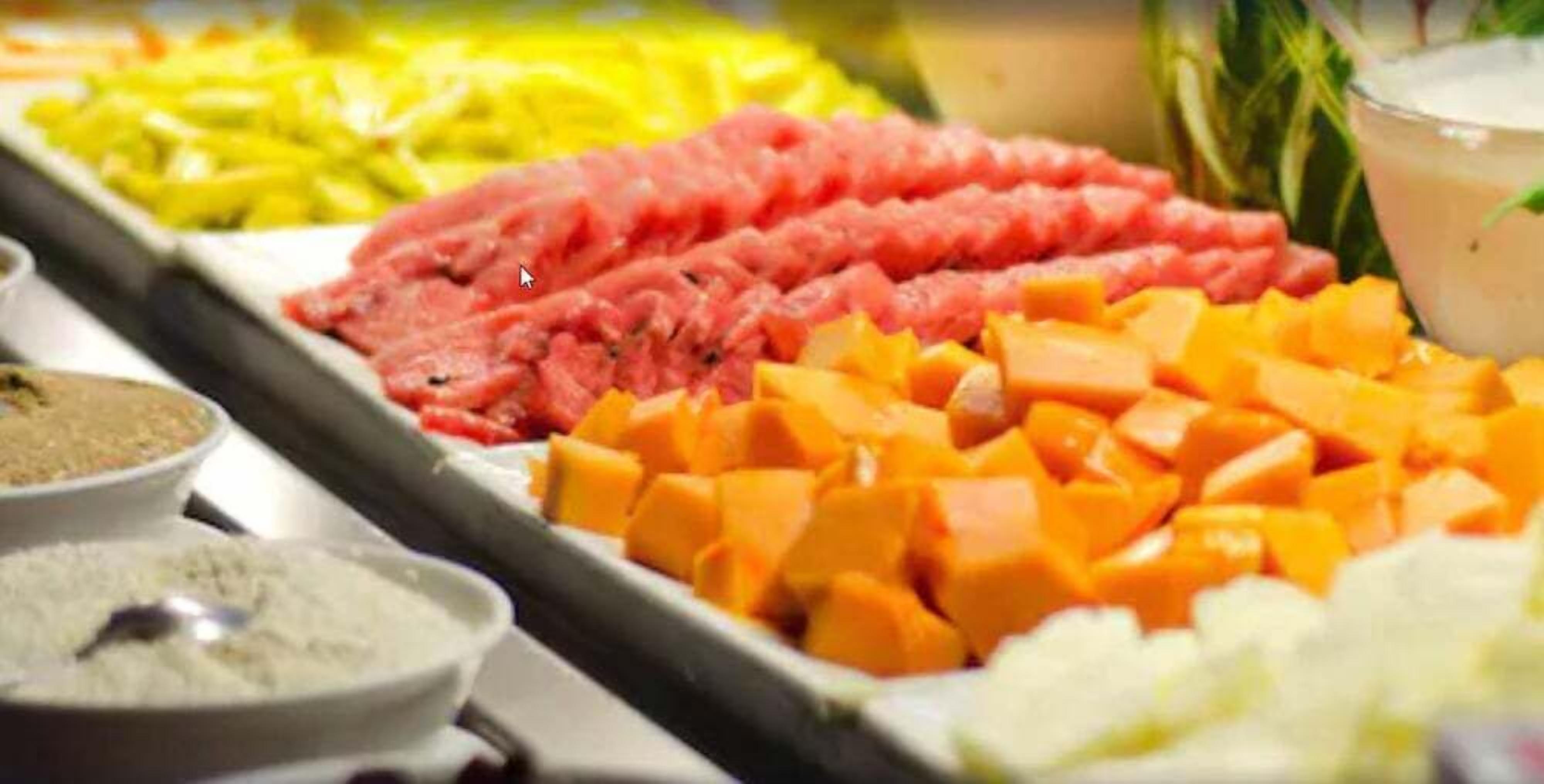 A buffet with various meat and vegetable options.