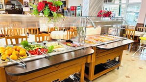 A buffet setup with various food items and a floral centerpiece.