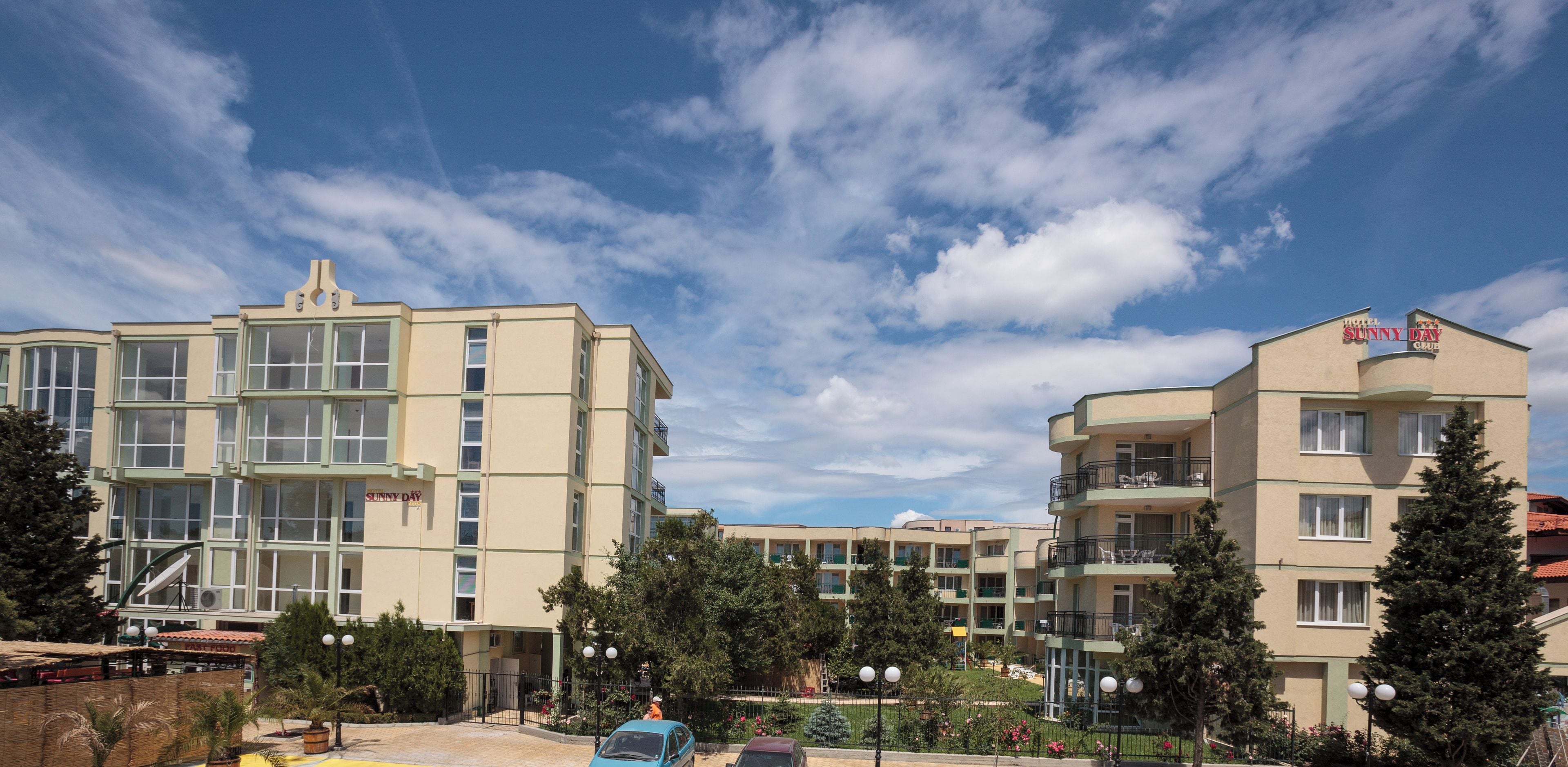 Ein Hotel mit mehreren Etagen, Balkonen und blauem Himmel.
