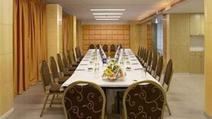 A conference room with a long table, chairs, and a floral centerpiece. - Hotel Satkar Residency (Thane)
