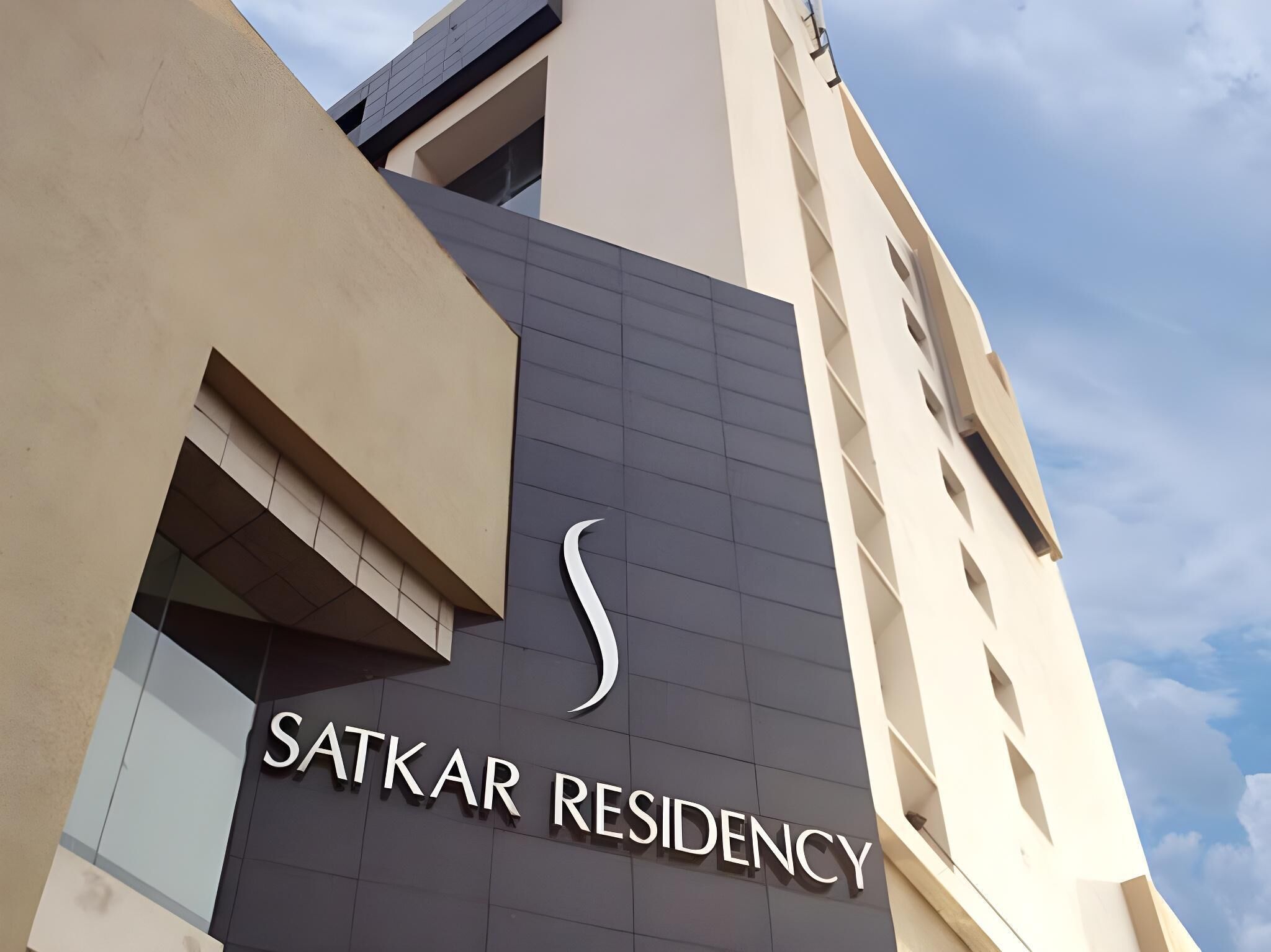 A building with a sign reading "SATKAR RESIDENCY".