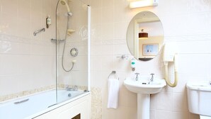 Een badkamer met een bad, wastafel, toilet en douche.