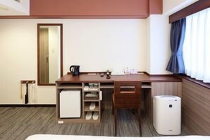 A hotel room with a desk, a mirror, a window with curtains, a radiator, and a small heater. - Cityroute Hotel (Osaka)
