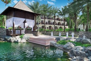 A resort with a pool, a covered seating area, and a multi-story building with balconies.