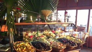 A buffet counter with various fruits and vegetables displayed in baskets. - Rubi Hotel (Alanya)