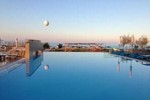 A clear pool with a view of the sea, a statue, and a pavilion. - Thalatta Seaside Hotel (Mantoudi-Limni-Agia Anna)