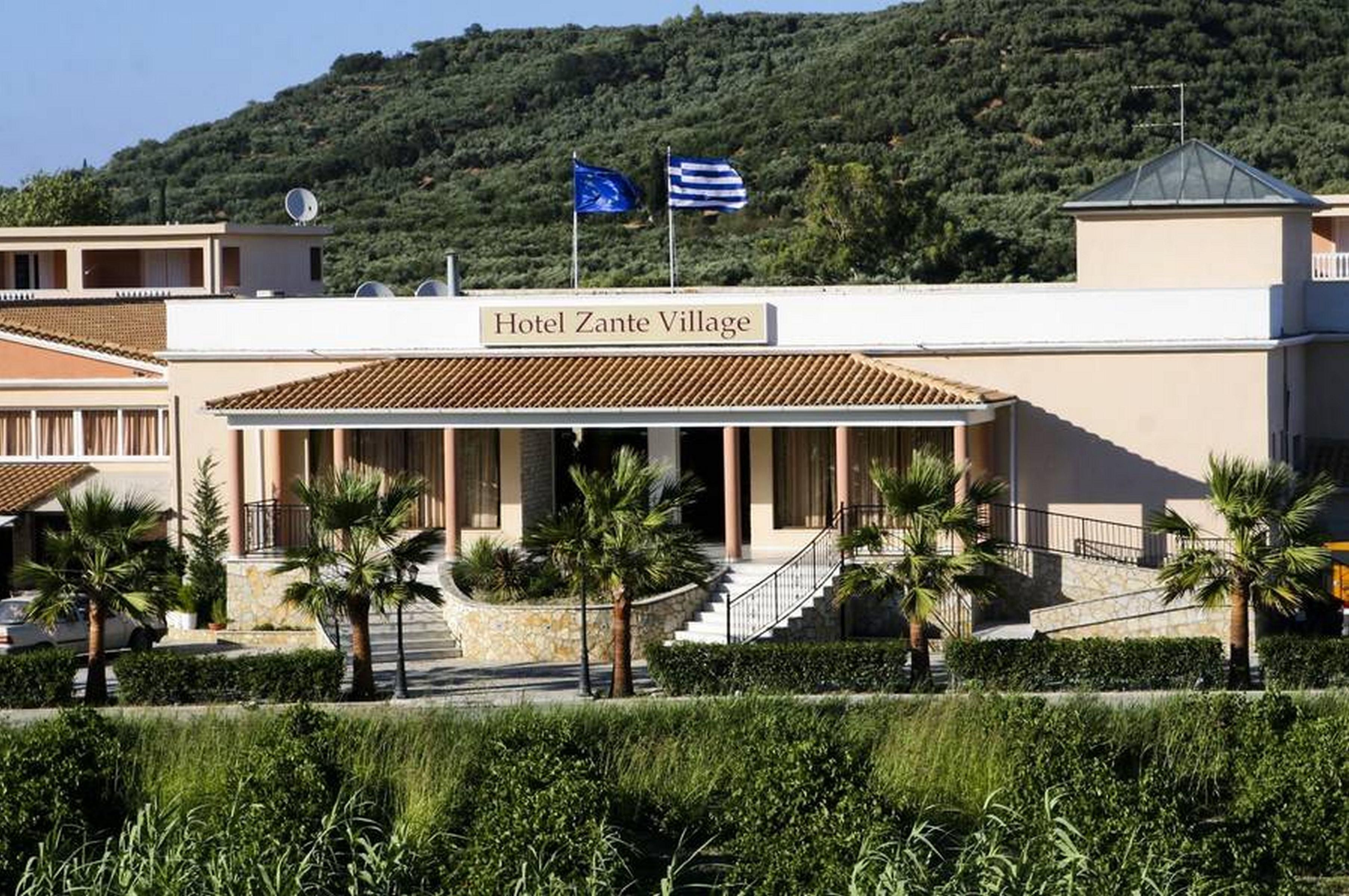 A building with a sign reading 'Hotel Zante Village.'