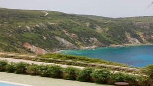 A coastal landscape with a road leading to a cliffside. - Niforos Panorama (Kefalonia)