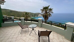 A terrace with a view of the ocean, equipped with chairs and a table. - Niforos Panorama (Kefalonia)