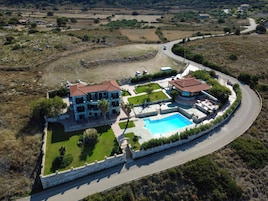 Una extensa propiedad con piscina, varias construcciones y un camino sinuoso.