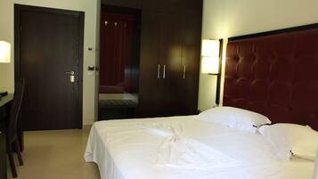 A hotel room with a bed, a desk, and a wardrobe.