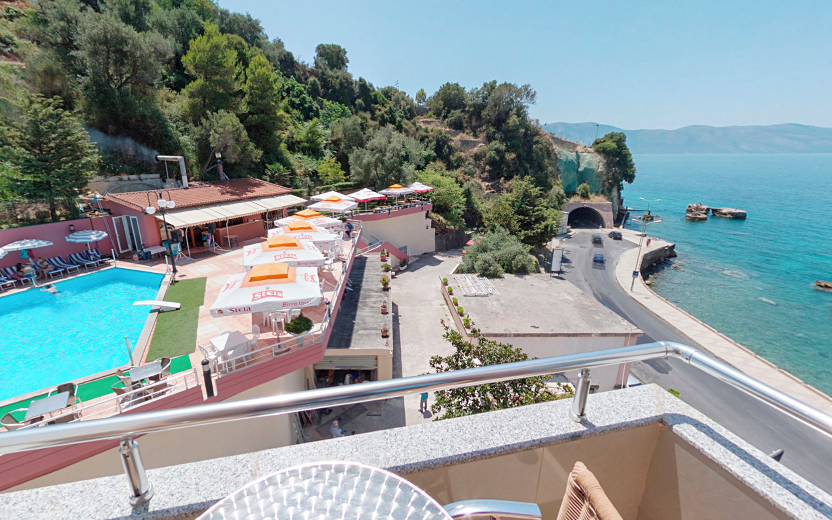 Un hôtel doté d’une piscine, de parasols et offrant une vue sur la mer.