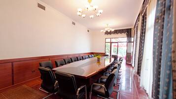 A conference room with a long table, chairs, and a chandelier.