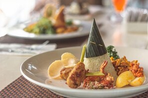 A plate of food with rice, vegetables, and a leaf on top. - Grand Barong Resort (Bali)