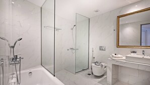 A modern bathroom with a glass-enclosed shower, a standalone bathtub, and a vanity with a mirror. - Delfina Boutique (Apokoronas)