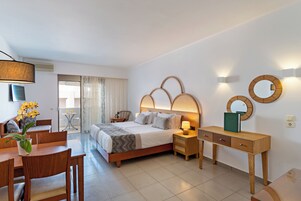Una habitación de hotel moderna con una cama, mesitas de noche, un escritorio y una zona de comedor.