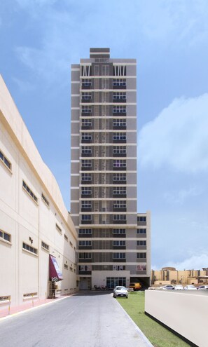 Un edificio alto y moderno con fachada simétrica, múltiples ventanas y techo plano.