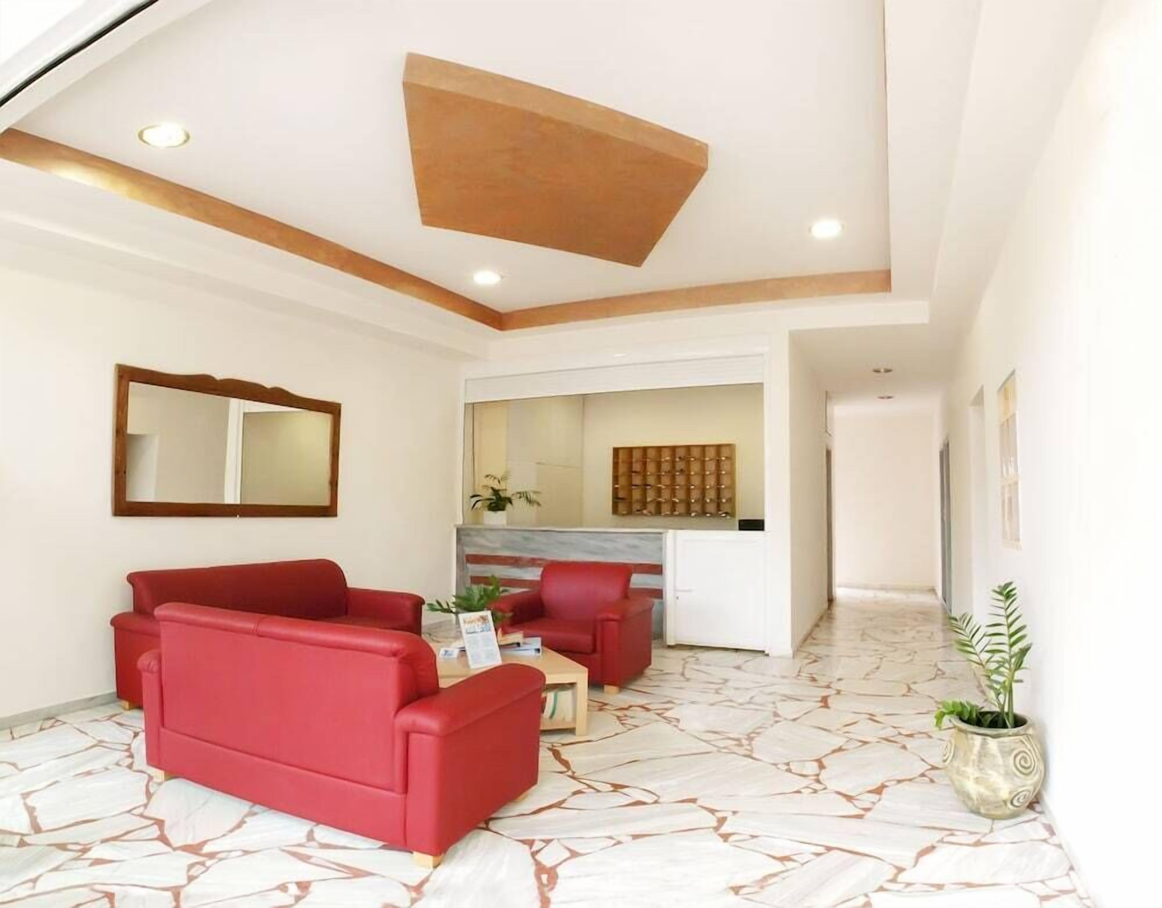 A modern living room with red sofas, a coffee table, and a fireplace.