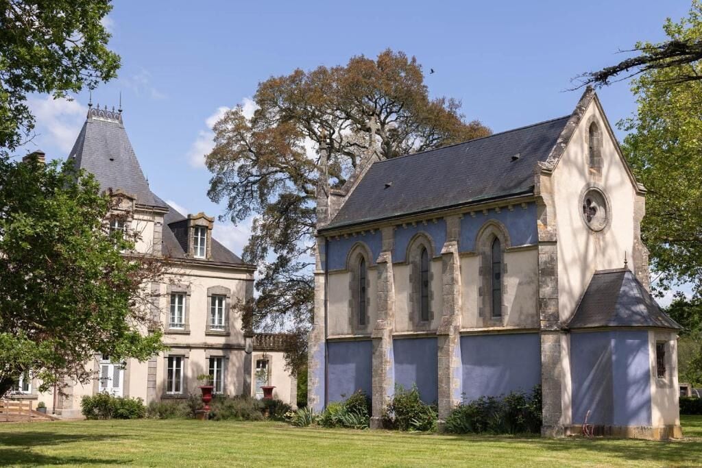 A historic building with a prominent tower and a smaller attached structure with arched windows.