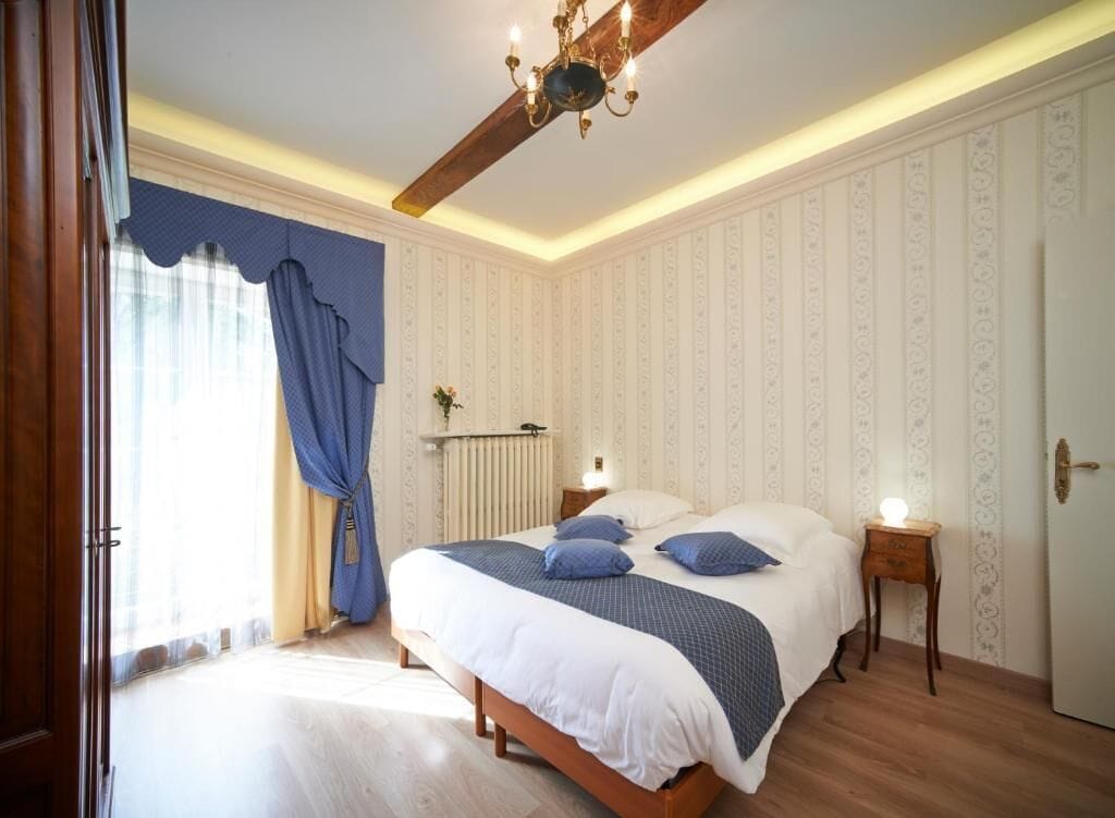 Un dormitorio con cama, mesita de noche, radiador y puerta.