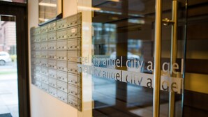 A glass door with a view of a row of mailboxes and a reflection of a car outside. - FriendHouse Apartments - City Center (Kraków)