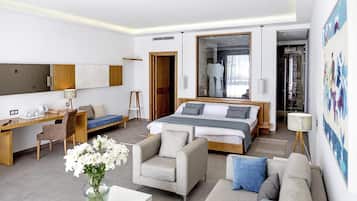 Una habitación de hotel moderna con una cama grande, un escritorio, un sofá y una silla.