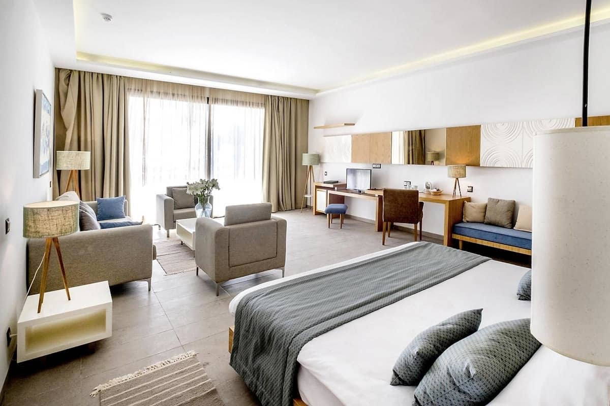Une chambre d’hôtel avec un grand lit, un bureau, un canapé et une chaise.