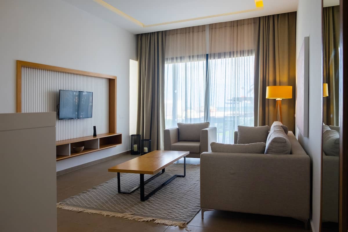 Un salon moderne avec un canapé, une table basse et un téléviseur fixé au mur.