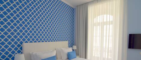 A hotel room with two beds, a nightstand with a phone, a TV on the wall, and a window with curtains.