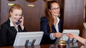 A reception desk with a clock, a telephone, and a cash register. - Plaza Hotel (Winterthur)