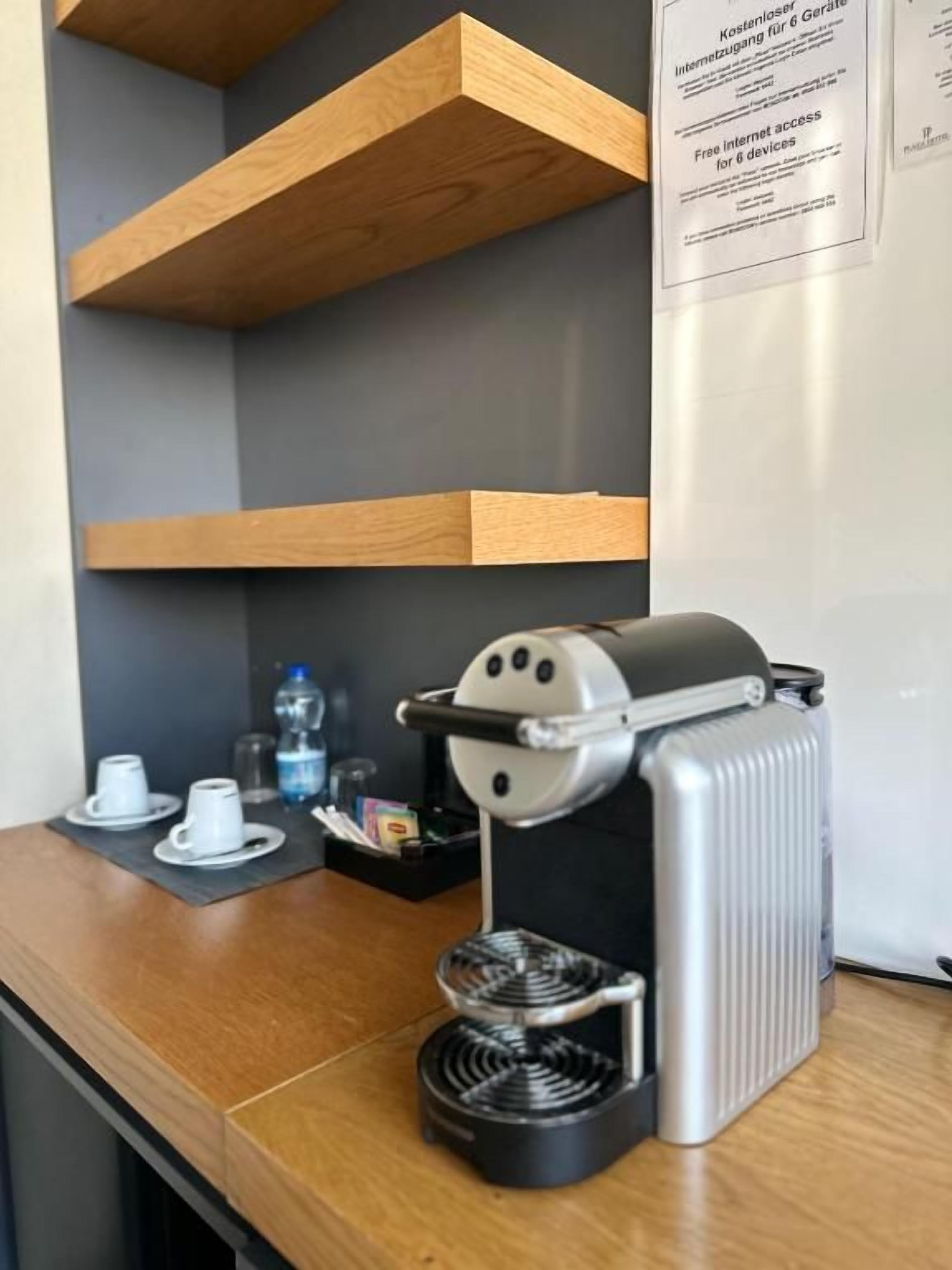Una máquina de café sobre una encimera con una botella de agua y tazas.
