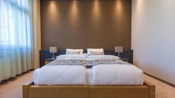 A modern bedroom with a large bed, two bedside tables, and a ceiling light fixture.