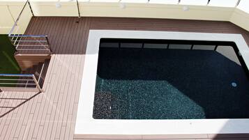 Una piscina rectangular con un borde de madera alrededor.