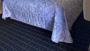 A hotel room with a large bed, a bedside table, a lamp, and a chair. - Mt Whitney Motel (Lone Pine)