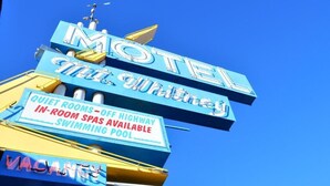 A motel sign with 'MOTEL' and 'The Whitney' written on it, along with amenities like quiet rooms, off highway in-room spas, and a swimming pool. - Mt Whitney Motel (Lone Pine)