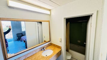Een bad/douchecombinatie, handdoeken