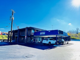 A two-story building with a 'Cumberland Inn' sign, a parking lot, and a white car parked in front.