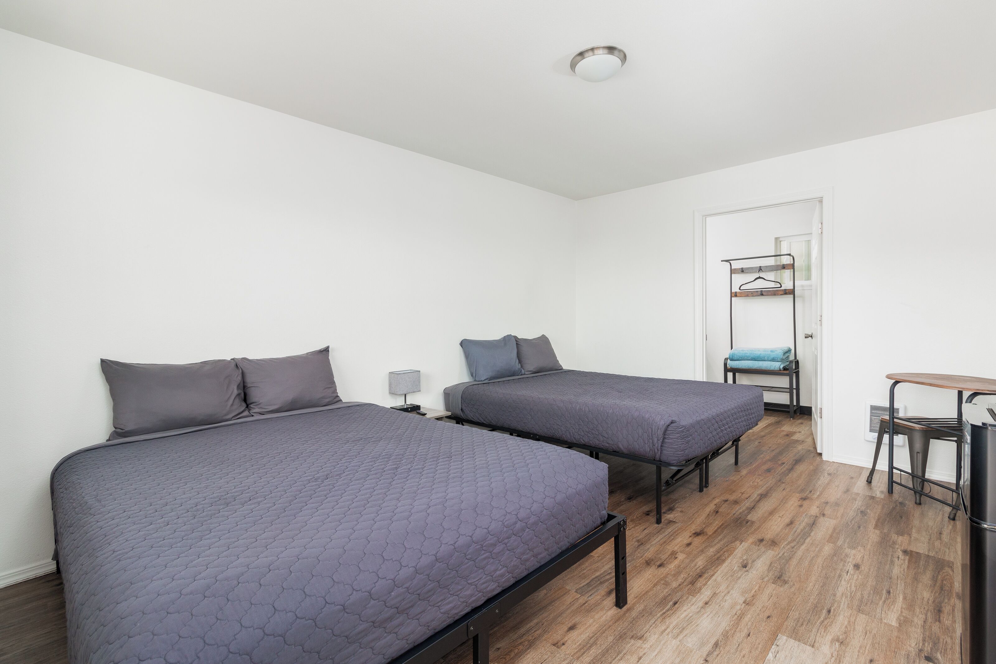 A room with two beds, a small table, and a chair.