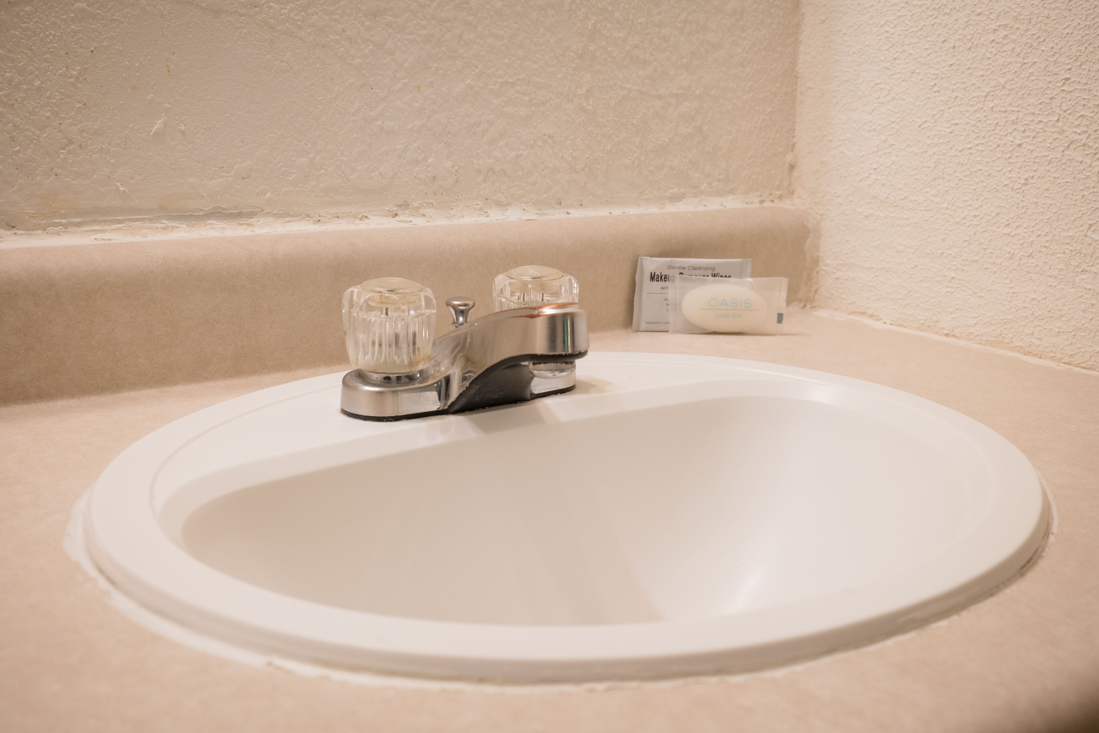 A bathroom sink with a modern faucet and a soap dispenser on the countertop.