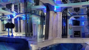 A luxurious room with a large bed, a private pool, and a mirrored wall reflecting the room's decor.
