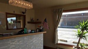 Ein Empfangsbereich mit einer Steintheke, einer amerikanischen Flagge, einem Blumentopf und Blick auf die Straße.
